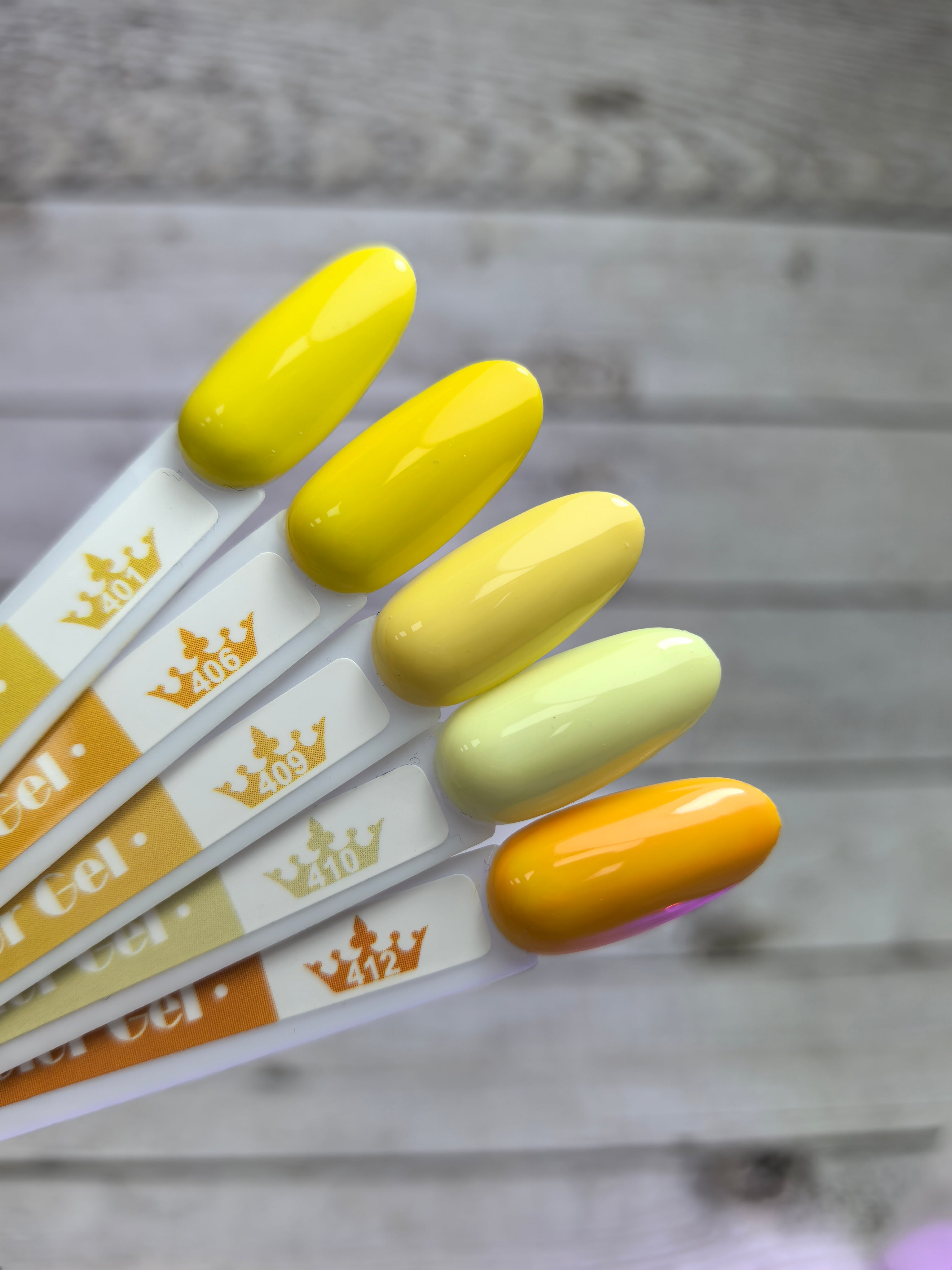Colorful gel nail polish samples displayed on wooden background