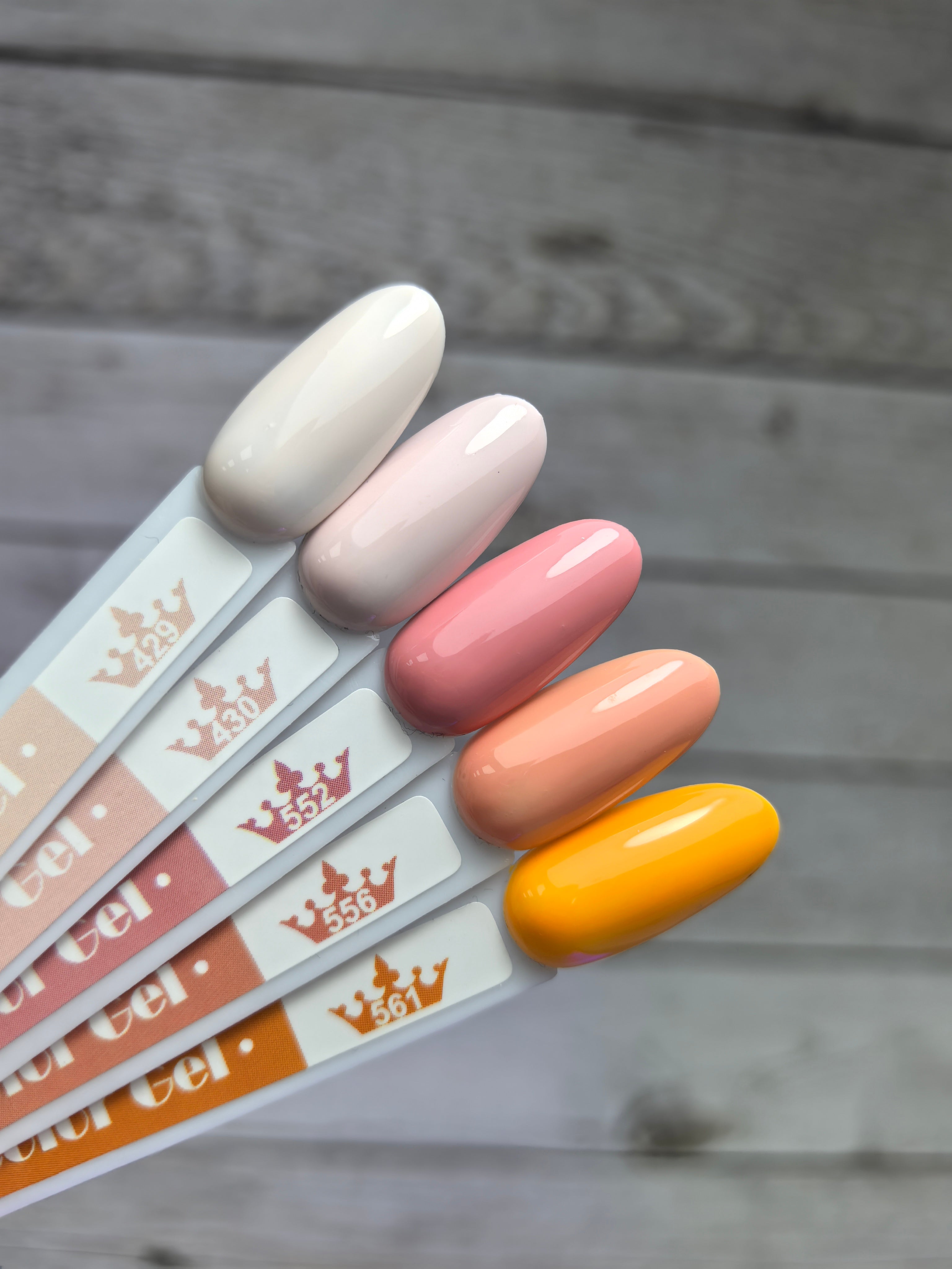 Гел лак 429 в неутрални и пастелни цветове, включително розово и оранжево, показани върху мостри за демонстрация на качеството.